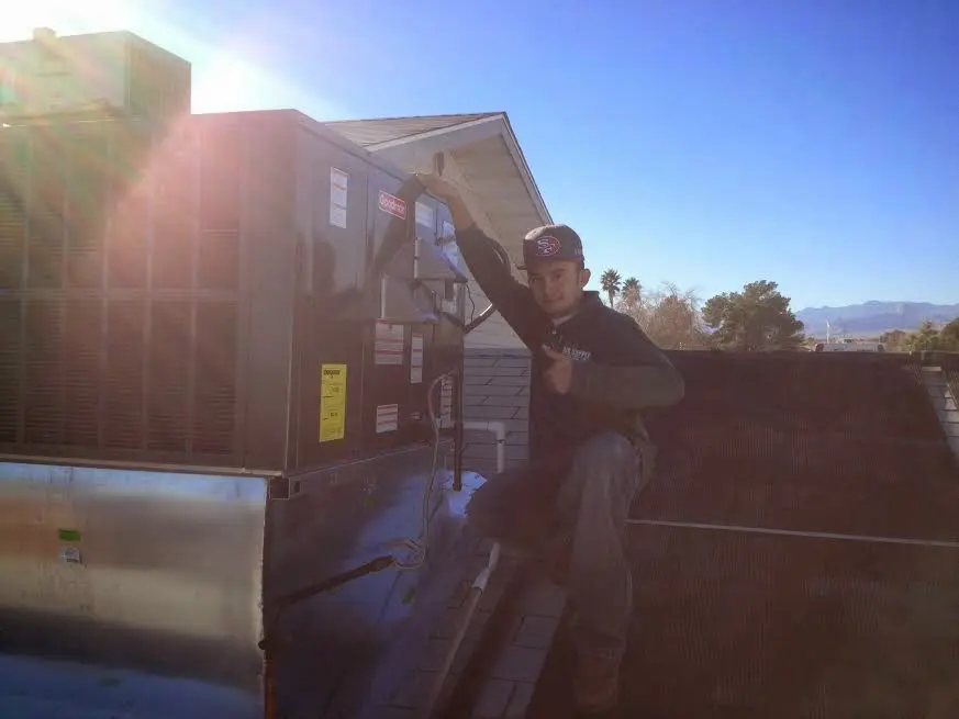 HVAC technician performing Boiler Repair on a rooftop unit in Pollock Pines